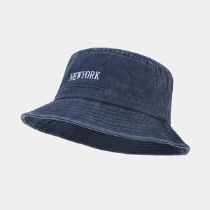 Detail of blue washed cotton bucket hat with white NEWYORK embroidery and metal eyelets