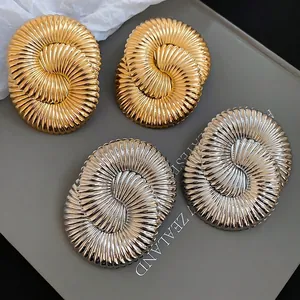 Statement oversized metallic stud earrings with geometric spiral texture in gold and silver