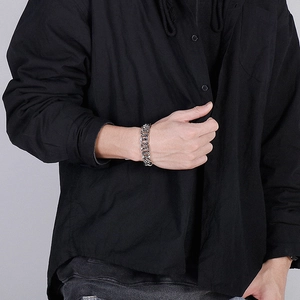 Close-up of a men's chunky stainless steel chain bracelet on a male model's wrist