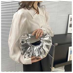 Detailansicht der silbernen Metallic-Tasche in Raffoptik mit rundem Griffdesign