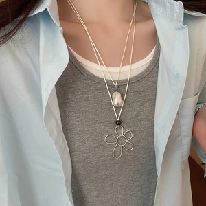 Close-up of double-layer necklace with baroque pearl and wire flower pendant