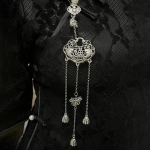 Detail of silver long life lock brooch with Fu character on black lace dress