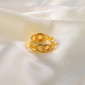 Macro shot of 18k gold plated chain link ring on white silk background with soft shadows