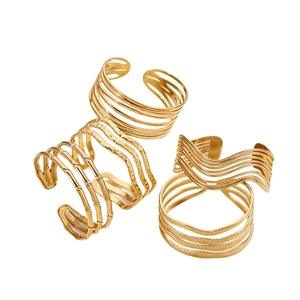 Set of four gold-plated multilayer open bangles with geometric and wave textures