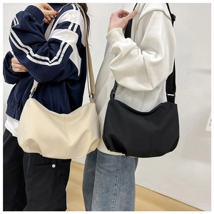 Fashionable minimalist pleated dumpling bags in black and creamy white on models