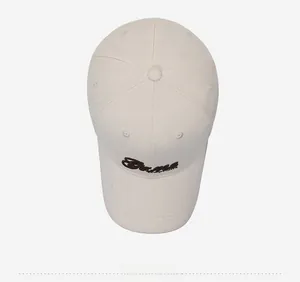Detail of embroidered 'Same' logo on cream cotton baseball cap with ventilation eyelets