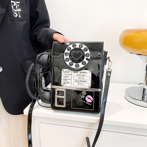 Detail of retro black patent leather telephone bag with dial design and handset handle