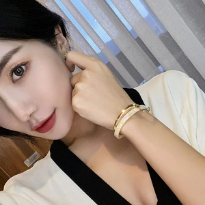 Minimalist gold plated double layer bangle featuring cream enamel and irregular geometric style