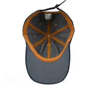 Detail view of denim baseball cap interior featuring 100% cotton label and orange stitching