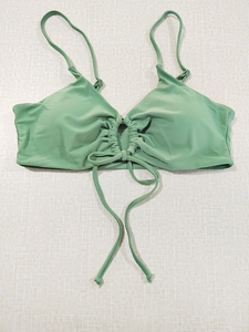 Detail of light green halter bikini top with ruched front and stylish tie-up design