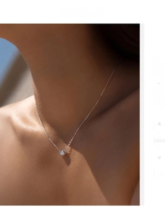 Detail of s925 silver hexagonal necklace with a clear crystal on a female model