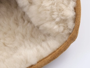 Macro shot of plush wool lining and tan suede exterior on warm winter snow boots