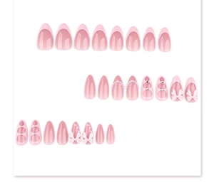 Detail of pink almond press-on nails with 3D bows, pearls and French tip designs