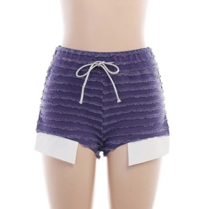 Détail d'un short en tricot violet avec bords effilochés, cordon argenté et doublure apparente