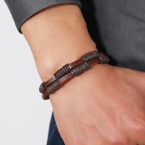 Detail of man wearing double-layer braided leather bracelet with vintage magnetic clasp