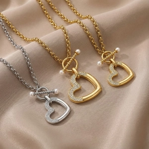 Détails des pendentifs cœur avec cristaux pavés et perles sur fond de soie