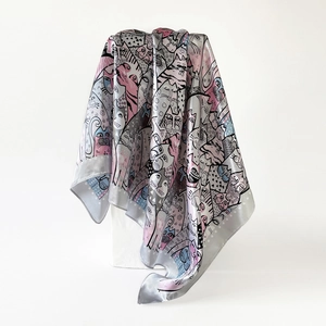 Detail of silk satin scarf featuring colorful cartoon cat prints draped over a white stand