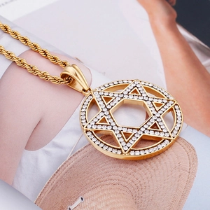 Macro detail of gold-plated hollow hexagram pendant with sparkling crystals on rope chain