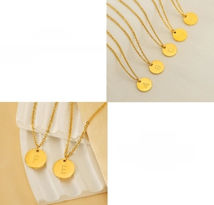 Détail de pendentifs ronds en acier inoxydable doré avec lettres A-F gravées