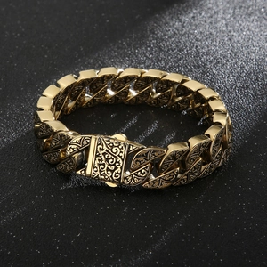 Close-up of vintage gold titanium steel cuban link bracelet with intricate floral engravings