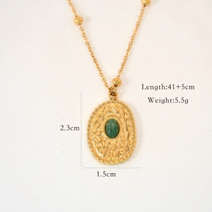 Macro detail of French vintage gold pea pendant with green gemstone and size specs