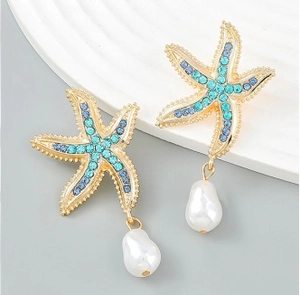 Detail of starfish drop earrings with blue rhinestones and irregular white pearl