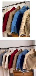 Close-up of color-block knit turtlenecks in various colors on wooden hangers