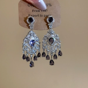 Detailed macro of vintage silver-tone drop earrings with purple teardrop gemstones