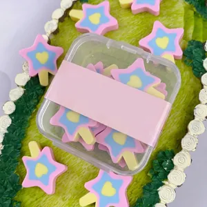 Detalle de gomas de borrar de piruleta con forma de estrella en una caja de plástico