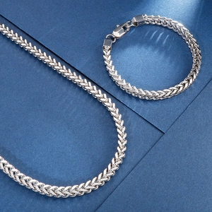 Gros plan sur l'ensemble collier et bracelet en chaîne de dragon en acier poli argent