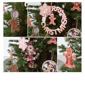 Detail of wooden gingerbread man and DIY photo frame hanging on Christmas tree