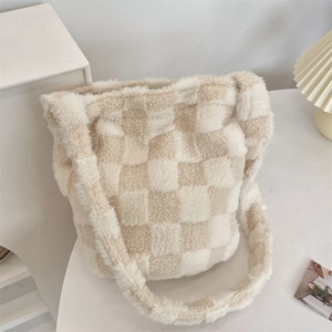 Close-up of plush faux fur shoulder bag with beige checkered pattern on white table