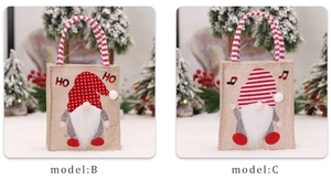 Detail of burlap Christmas gnome gift bags with 3D applique and festive striped handles