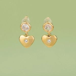Golden heart drop earrings featuring sparkling round crystals on a light green background
