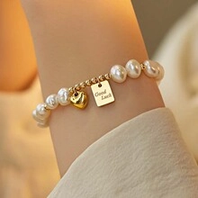 Detail of freshwater pearl bracelet with gold heart charm and Good Luck tag