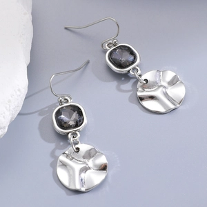 Detail of silver drop earrings with faceted gray crystals and hammered irregular metal plates