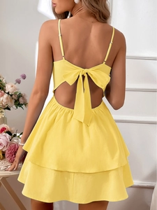 Detail of yellow cotton dress featuring a large back bow tie and tiered skirt layers