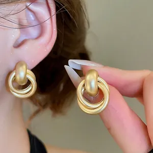 Matte gold interlocking geometric hoop earrings with a minimalist double ring design