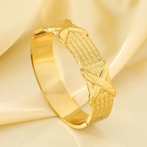 Detail of 18K gold plated stainless steel cuff with mesh texture and X shape symbols