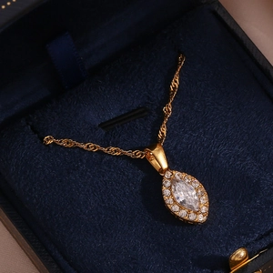 Close-up of a gold marquise crystal pendant necklace in a navy velvet jewelry box