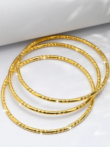 Détail de quatre bracelets fins plaqués or 24K avec textures spirales taillées diamant