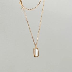 Close-up of S925 sterling silver gold plated necklace with shell stone inlay pendant