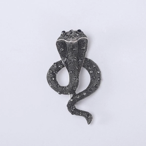 Close-up of vintage cobra brooch with antique silver finish and black gemstone eyes