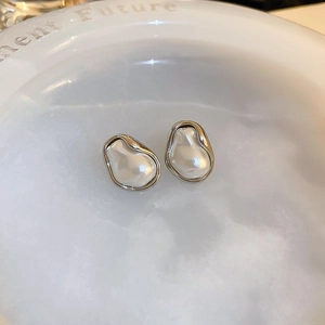 Macro shot of silver-plated irregular pearl earrings with liquid metal texture