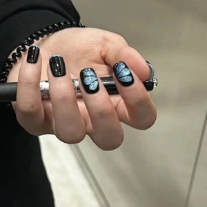 Faux ongles carrés courts noirs avec pointes French bleues et motif papillon pailleté