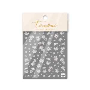 Detail shot of thin flexible semi-transparent white floral nail art stickers on dark card