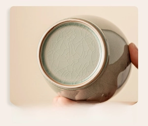 Close-up of smooth polished bottom on celadon ceramic tea jar with ice crackle glaze