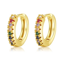 Close-up of gold-plated hoop earrings with multi-colored zircons and polished finish