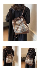 Detail view of vintage brown leather and plaid fabric backpack with metal buckle accents