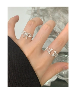 On-hand view of 925 sterling silver bow knot rings with hollow geometric design
